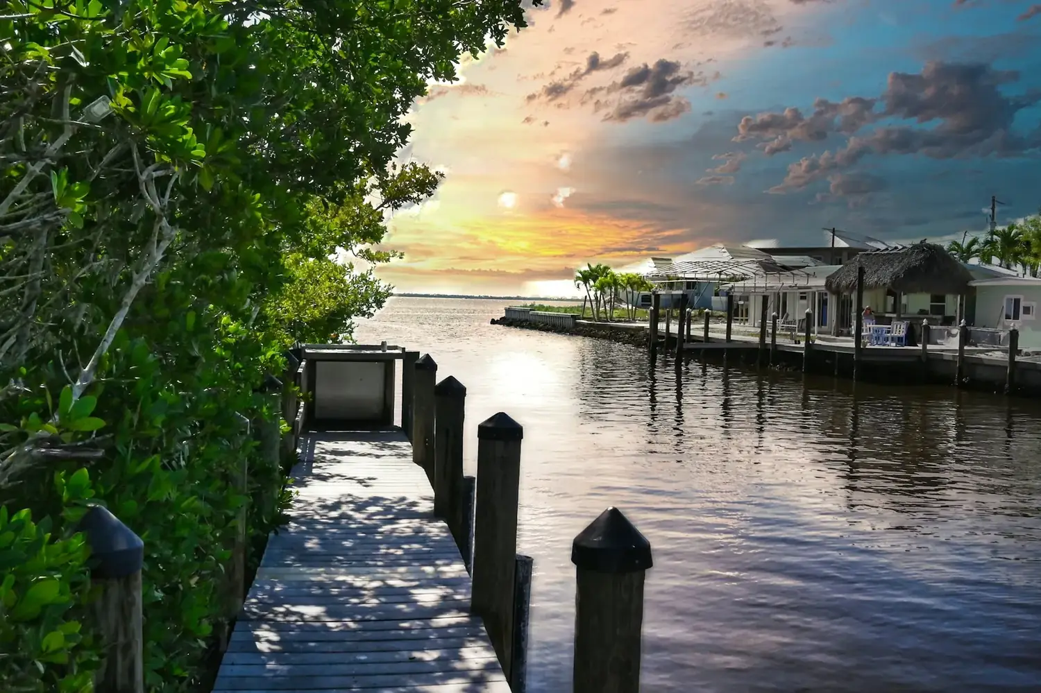 A wooden dock reaching into Central Florida water at sunset